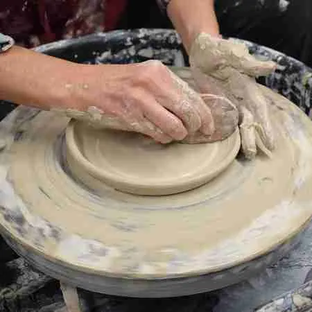 Person making pottery on the wheel