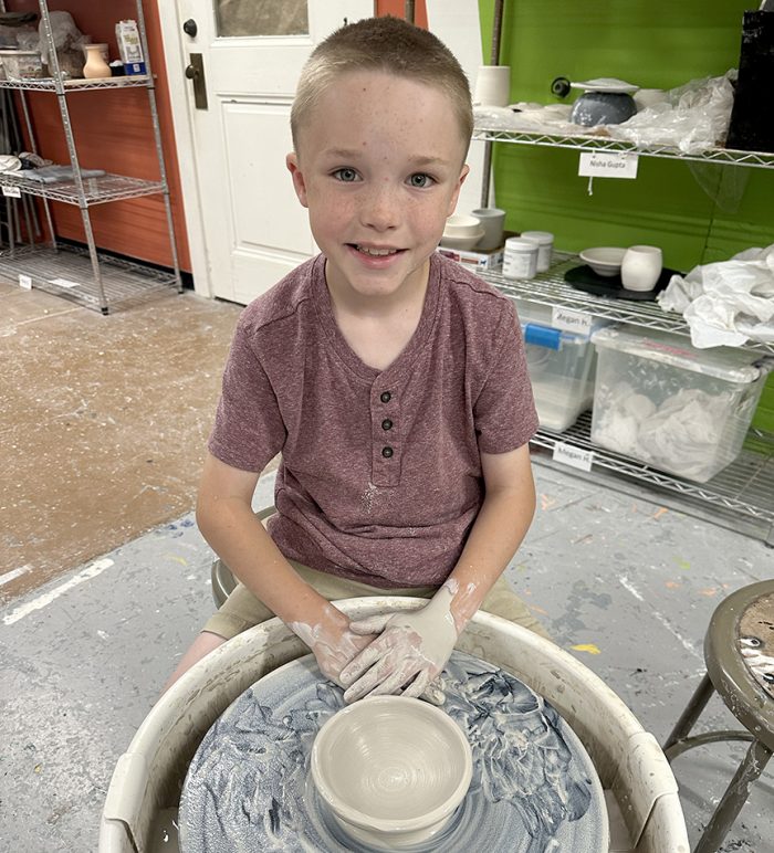 Child making pottery on a potter's wheel at Art Center of the Bluegrass in Danville, Kentucky